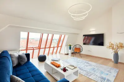 a living room with a blue couch and a tv at Karlova Old Town Apartments in Prague