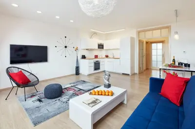 a living room with a blue couch and red pillows at Karlova Old Town Apartments in Prague