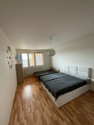 a bedroom with a bed and a clock on the wall at Apartment 153 - Rezidence Eliska - Prague 9 in Prague