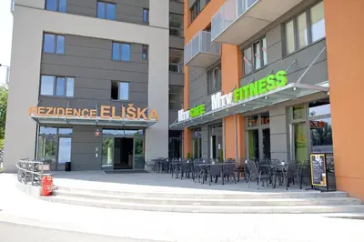 a hotel with tables and chairs in front of a building at Apartment 153 - Rezidence Eliska - Prague 9 in Prague