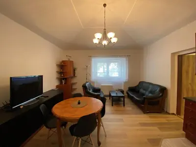 a living room with a table and chairs and a television at Penzion Mořina in Mořina