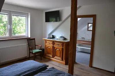 a bedroom with a desk and a sink and a mirror at Penzion Mořina in Mořina