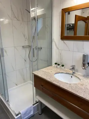 a bathroom with a shower and a sink and a tub at Penzion Mořina in Mořina