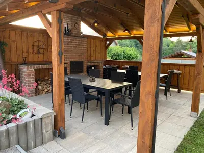 a patio with a table and chairs and a fireplace at Penzion Mořina in Mořina