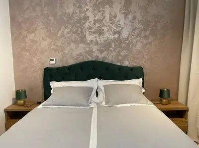 a bed with a green headboard and white pillows at Centrum Prague - Aloha Apartment in Prague
