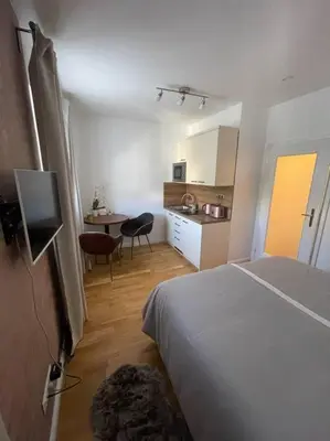 a bedroom with a bed and a kitchen with a table at Centrum Prague - Aloha Apartment in Prague