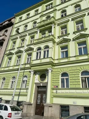 a green building with cars parked in front of it at Centrum Prague - Aloha Apartment in Prague