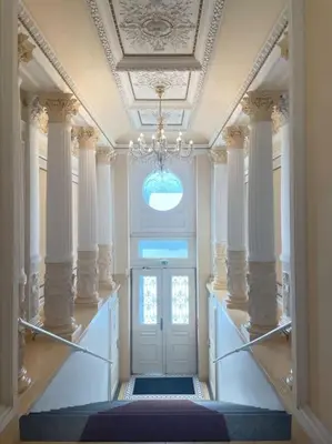 a hallway with a door with columns and a chandelier at Centrum Prague - Aloha Apartment in Prague