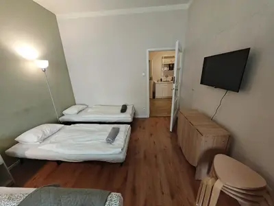 a room with two beds and a flat screen tv at Flat in Zizkov -101- in Prague