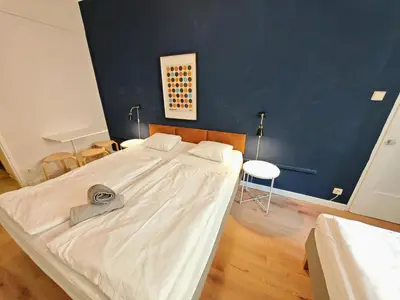 a large white bed in a room with a blue wall at Flat in Zizkov -101- in Prague