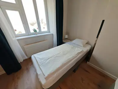 a small bed in a room with a window at Flat in Zizkov -101- in Prague