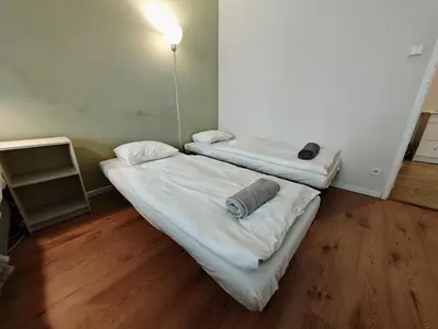 two beds in a room with wooden floors at Flat in Zizkov -101- in Prague