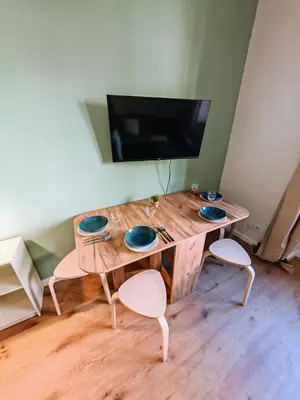 a wooden table with two chairs and a tv at Flat in Zizkov -102- in Prague