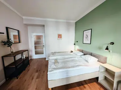 two beds in a bedroom with green and white walls at Flat in Zizkov -102- in Prague