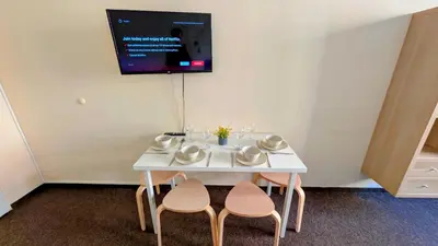 a white table with two chairs and a tv on the wall at Flat in Zizkov -103- in Prague