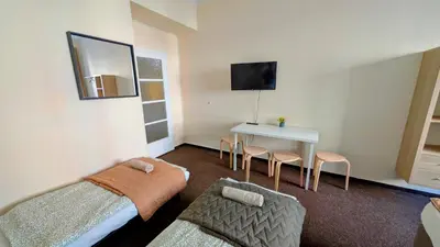 a small room with a bed and a table and chairs at Flat in Zizkov -103- in Prague