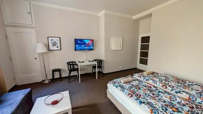 a bedroom with a bed and a table and a tv at Flat in Zizkov -104- in Prague