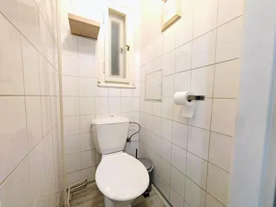 a white bathroom with a toilet and a window at Flat in Zizkov -104- in Prague