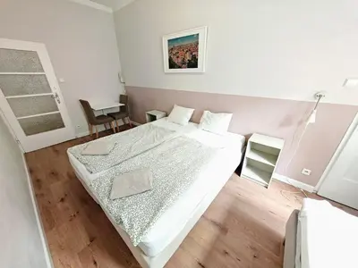 a bedroom with a large white bed and a table at Apartment in Zizkov -201- in Prague