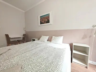 a white bedroom with a bed and a desk at Apartment in Zizkov -201- in Prague