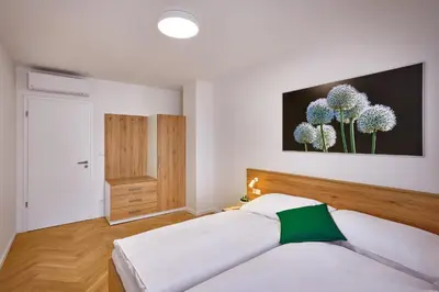 a bedroom with a bed and a painting on the wall at DownTown Suites Rubesova in Prague