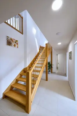 a staircase in a home with white walls and wooden rails at DownTown Suites Rubesova in Prague