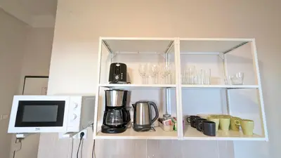 a white cabinet with a coffee maker and a microwave at Apartment in Zizkov -202- in Prague