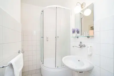 a white bathroom with a sink and a shower at Apartment in Zizkov -202- in Prague