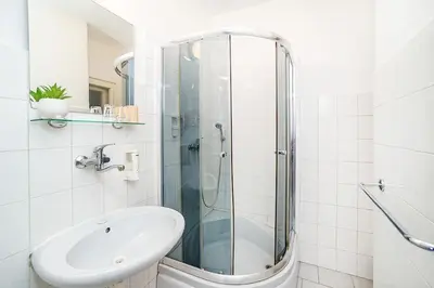 a bathroom with a glass shower and a sink at Apartment in Zizkov -203- in Prague