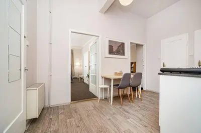 a white apartment with a table and chairs and a hallway at Apartment in Zizkov -203- in Prague