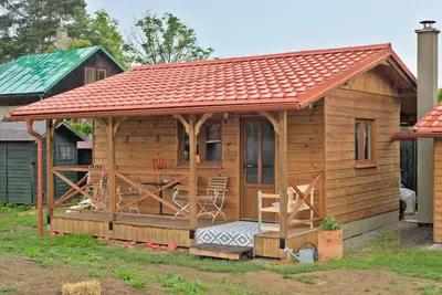 a wooden cabin with a red roof at Bouda Berounka in Lety