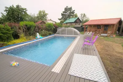 a swimming pool with a purple chair on a deck at Bouda Berounka in Lety