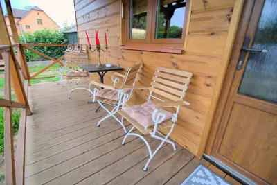 a porch with chairs and a table and a door at Bouda Berounka in Lety