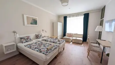 a hotel room with two beds and a desk and a desk at Flat in Zizkov -204- in Prague