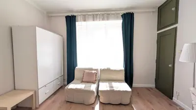 a living room with a white chair and a window at Flat in Zizkov -204- in Prague