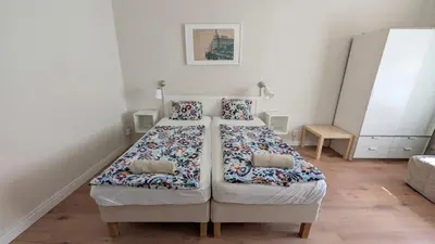 two beds in a small room with white walls at Flat in Zizkov -204- in Prague