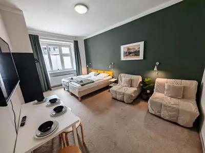 a living room with a couch and a bed and chairs at Apartment in Zizkov -301- in Prague