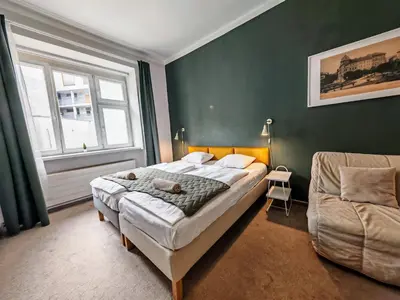 a bedroom with a large bed and a chair at Apartment in Zizkov -301- in Prague
