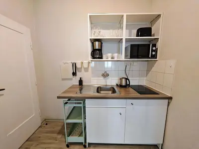 a small kitchen with white cabinets and a sink at Apartment in Zizkov -301- in Prague