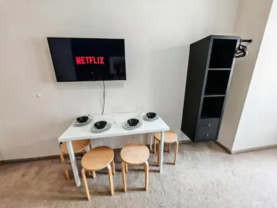 a white table with chairs and a tv on a wall at Apartment in Zizkov -301- in Prague