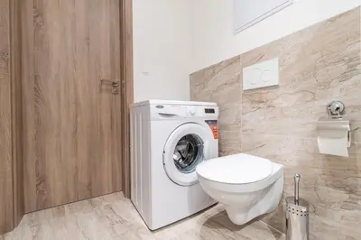 a bathroom with a washing machine and a toilet at Brand new two room apartment #34 with free secure parking in the center in Prague