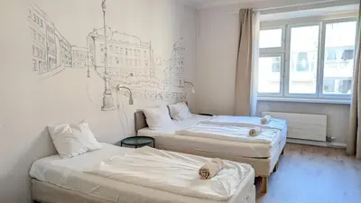 two beds in a room with drawings on the wall at Flat in Zizkov -302- in Prague