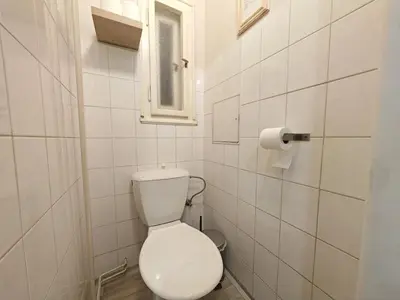 a white bathroom with a toilet and a window at Flat in Zizkov -302- in Prague