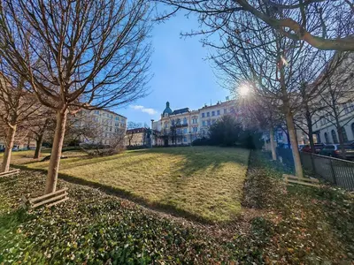 a park with trees and buildings in a city at Flat in Zizkov -302- in Prague