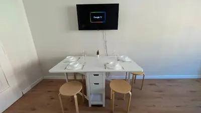 a white table with two chairs and a clock on the wall at Flat in Zizkov -302- in Prague