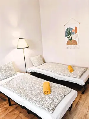 a room with two beds with yellow pillows and a lamp at Flat in Zizkov -303- in Prague