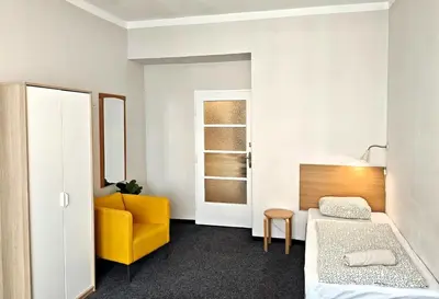 a room with a bed and a yellow chair at Flat in Zizkov -303- in Prague