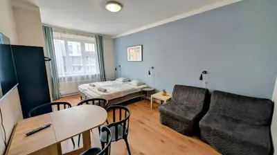 a living room with a bed and a table and chairs at Flat in Zizkov with free underground parking -501- in Prague