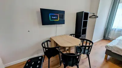a room with a table and chairs and a tv on the wall at Flat in Zizkov with free underground parking -501- in Prague