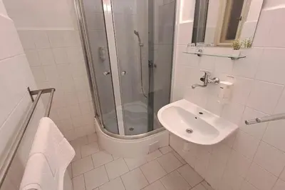 a white bathroom with a shower and a sink at Flat in Zizkov -402- in Prague